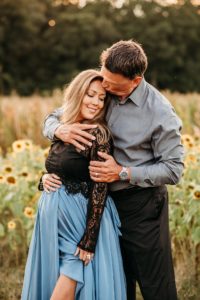 dad snuggling into pregnant wife for a kiss